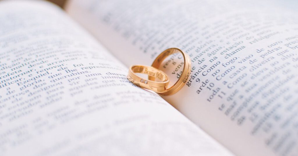 Close-up of wedding rings resting on the pages of an open book, symbolizing love and commitment.