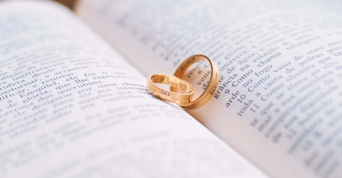 Close-up of wedding rings resting on the pages of an open book, symbolizing love and commitment.